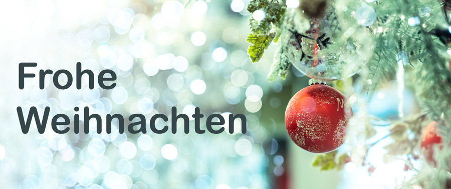Rote Weihnachtskugel hängt an einem Tannenzweig